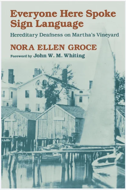 Book cover for Everyone Here Spoke Sign Language by Nora Ellen Groce, featuring a sepia-toned photo of Martha’s Vineyard with boats, docks, and old wooden buildings by the water.